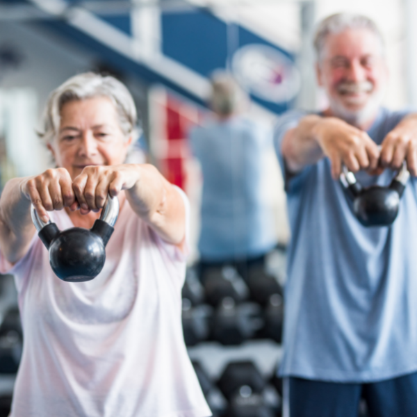 senior couple with Parkinson's disease doing kettlebell lifts